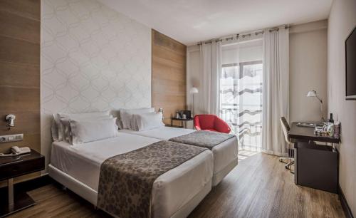 科尔多瓦NH收藏阿米斯塔德科尔多瓦酒店的一间设有大床和窗户的酒店客房