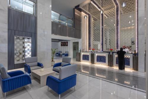 麦地那فندق بلينسية Balensia Hotel的大堂设有2把蓝色椅子和桌子
