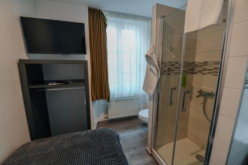 拉绍德封法国酒店的带淋浴和卫生间的浴室以及电视。
