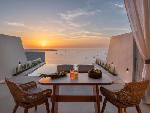伊亚Santo Mine Oia Suites的海景阳台上的桌子