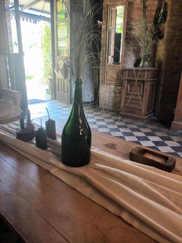 查斯科穆斯Hostería Casa de Campo的木桌上方的绿瓶