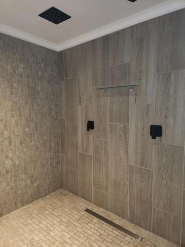 斯托姆勒菲Tsitsikamma Garden Chalets的浴室铺有木质瓷砖,设有淋浴。