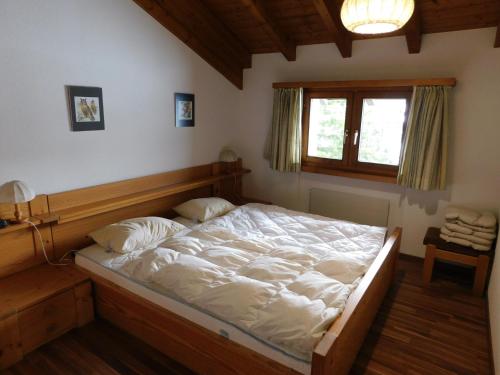 贝尔瓦尔德Ferienwohnung Silberdistel 2. Obergeschoss的一间卧室配有一张带白色床单的床和一扇窗户。