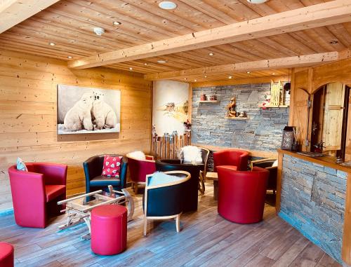 莫尔济讷Hameau des Prodains - Hôtel的一间设有红色和蓝色椅子的餐厅,并拥有砖墙