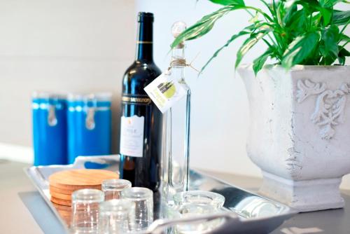 萨格勒布Zagreb Lodge Apartman 1的一张桌子,上面放着两瓶葡萄酒和一个花瓶
