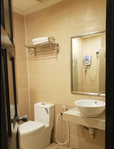 斗湖Kingston Executive Hotel的一间带水槽、卫生间和镜子的浴室