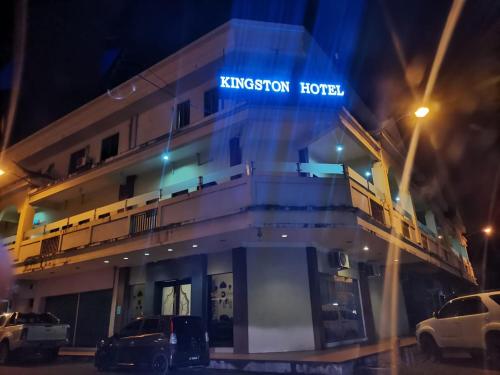 斗湖Kingston Executive Hotel的国王伯里酒店(Kingsbury hotel at night with cars parked in front)