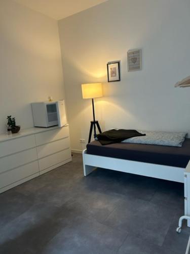 布雷茨费尔德Apart das Ehrets的一间卧室配有一张带灯具的床和一台电视