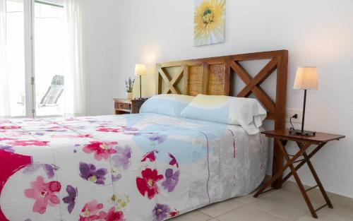 安波拉Baconer - Casa en l'Ampolla con jardín privado y acceso directo al mar - Deltavacaciones的一间卧室配有一张带花卉床罩的床
