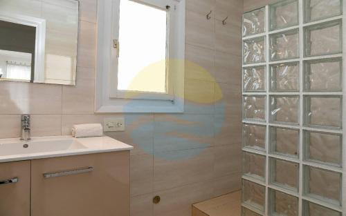 安波拉Baconer - Casa en l'Ampolla con jardín privado y acceso directo al mar - Deltavacaciones的一间带水槽、窗户和淋浴的浴室