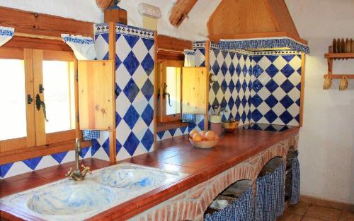 圣海梅-德恩韦哈Barraca típica del Delta, con piscina, jardín y barbacoa - Deltavacaciones的厨房配有水槽以及蓝色和白色的瓷砖