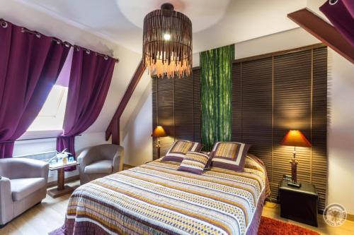 CahagnesLe Pont de Benneville的一间卧室配有一张带紫色窗帘和吊灯的床。