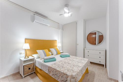 厄尔梅达诺Petite Homes Beach的一间卧室配有一张大床和镜子