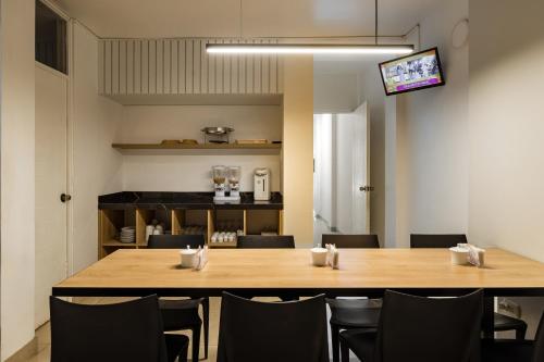 齐克拉约ESCALA BUSINESS HOTEL的一间会议室,配有木桌和椅子