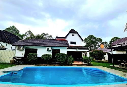Kampong Alor GajahPrivate 4Bedroom Villa Pool,BBQ,Karaoke, Afamosa Resort的前面有一个蓝色游泳池的房子