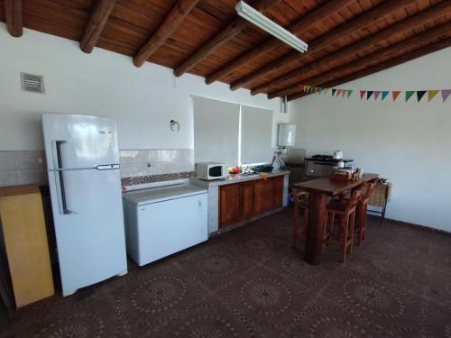 迈普Finca Las Acacias的厨房配有白色冰箱和木桌