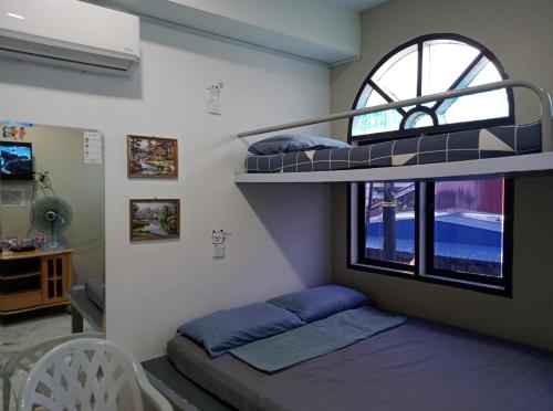 马六甲Thian Siong Inn的客房设有两张双层床和一扇窗户。