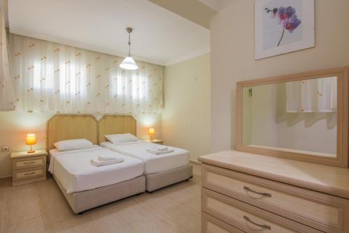 厄吕代尼兹Golden Trio Villa的一间卧室设有两张床和大镜子