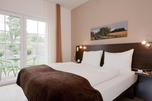 Kirchhatten迈纳斯酒店的一间卧室设有一张大床和大窗户