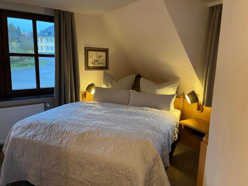 维林根Hotel zum Forsthaus的卧室配有白色的床和窗户。
