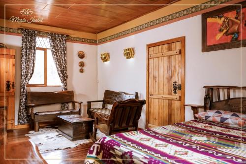 GualaceoQuinta maría isabel. Elegante y restaurada的卧室配有床、椅子和窗户。