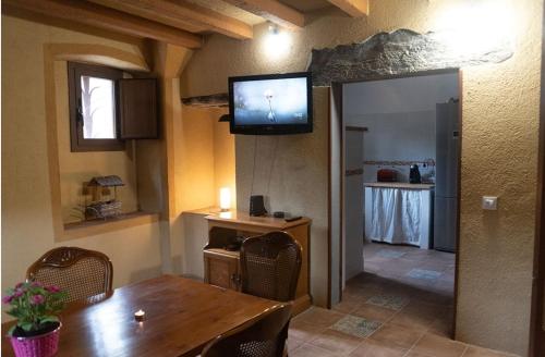 蒙塞尼Masia Casa Nova de n'Illa的一间用餐室,配有一张桌子和一台墙上的电视