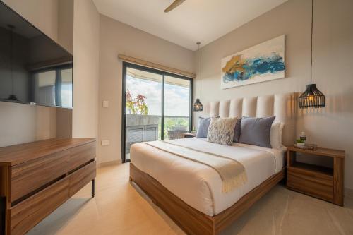 科苏梅尔Kippal - Modern Oasis - ApartHotel的一间卧室设有一张大床和一个大窗户