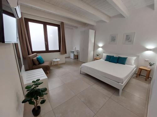 伊格莱西亚斯DoMe Affittacamere的卧室配有一张白色的大床和一张沙发。