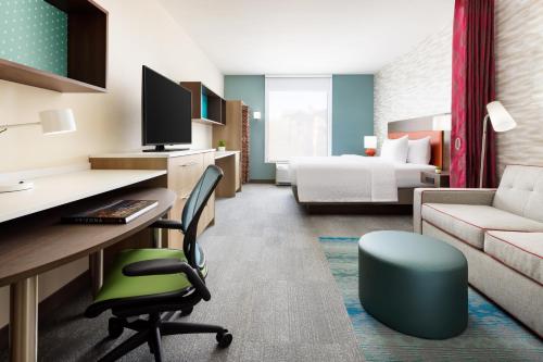 玛丽湖Home2 Suites By Hilton Lake Mary Orlando的酒店客房配有书桌和床。