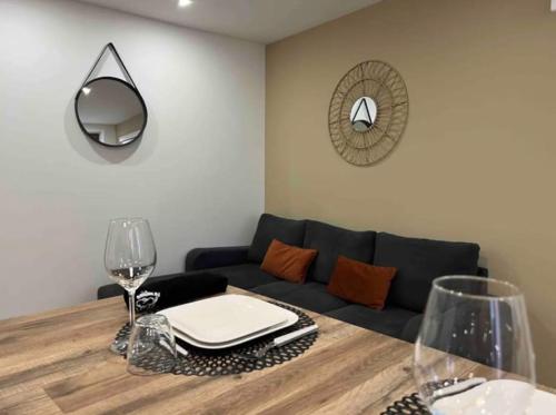 加普Appartement chaleureux en hyper centre de Gap的客厅配有沙发和带酒杯的桌子
