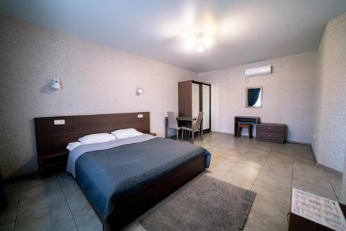 PogrebyРайский Дворик的酒店客房配有一张床铺和一张桌子。
