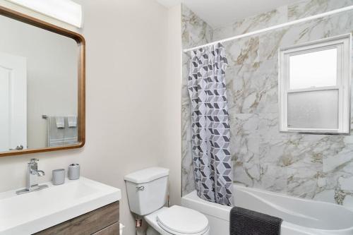 金斯顿Fields Inn Executive Townhouse的浴室配有卫生间、浴缸和水槽。