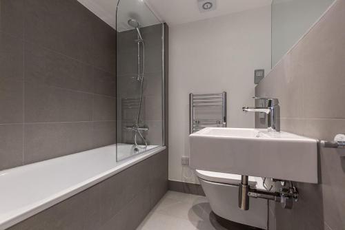 伦敦Kensington Olympia Apartment, Breakfast的一间带水槽、浴缸和卫生间的浴室