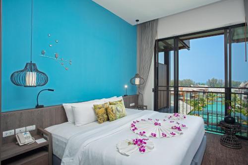蔻立普吉岛-迈考海滩水疗度假村PL- Maikhaolak Beach Village的一间卧室设有一张蓝色墙壁的大床
