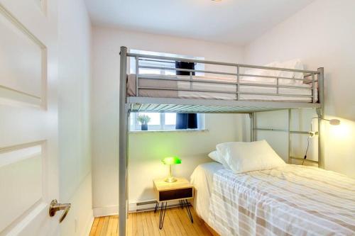 魁北克市La Maison Grenier La Résidence Beauport的一间卧室配有一张双层床和一张带台灯的桌子