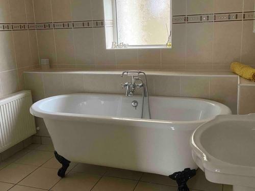 格伦贝赫Cois Locha的浴室配有白色浴缸及水槽