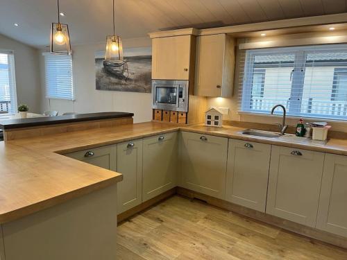 奇切斯特Lakeview Lodge的厨房铺有木地板,配有白色橱柜。