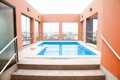 利马Los Tallanes Hotel & Suites的一座室内游泳池,位于一座带窗户的建筑中