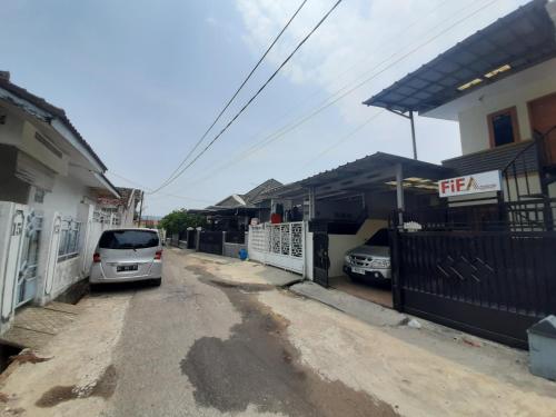 TanjungkarangFifa Homestay & Villa 2BR的停在房子旁边的街道上的汽车