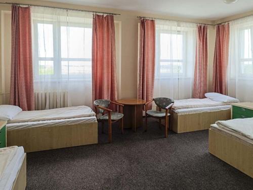 库特诺Sami Swoi Kutno的一间设有两张床和一张桌子及椅子的房间