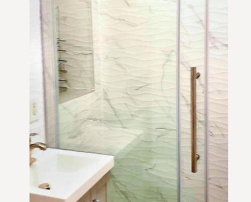 纽约Stunning 3BR Apartment in NYC!的带淋浴和白色盥洗盆的浴室