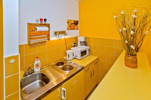 赫瓦尔Villa Softic的黄色的厨房配有水槽和微波炉