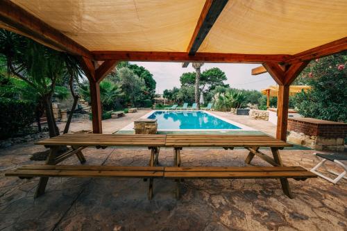 纳克萨Private Villa的一个带野餐桌和游泳池的凉亭