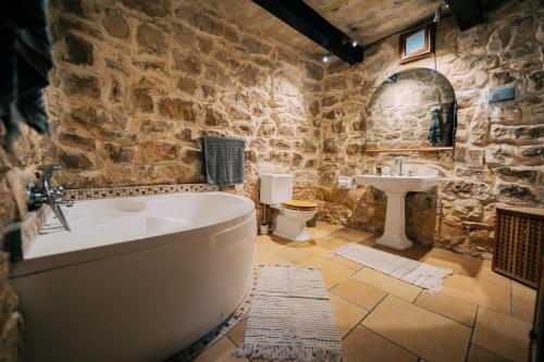 纳克萨Private Villa的带浴缸和水槽的石质浴室