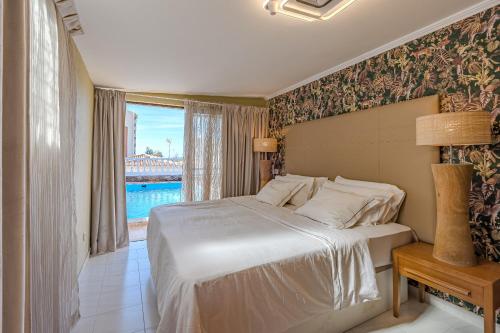 洛斯克里斯蒂亚诺斯Villa 4bed private pool en Los Cristianos的一间卧室配有一张床,享有桥梁的景致
