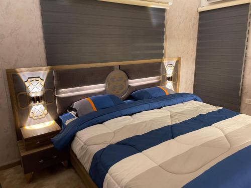 伊尔比德شركة مسايا لشقق المفروشة的一间卧室配有一张带蓝白色床单的大床