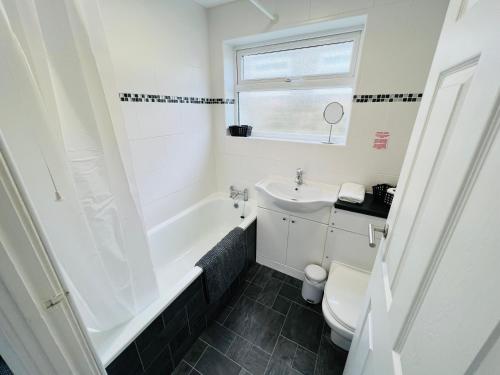 Brading2 Bedroom Chalet SB172, Sandown Bay, Isle of Wight, Free WiFi的白色的浴室设有水槽和卫生间。
