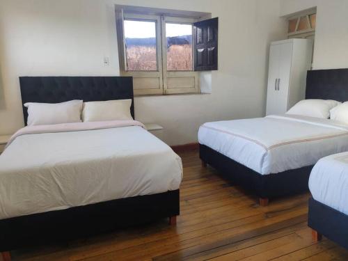 库斯科Departamento en Centro histórico de Cusco (PASEO LOS HEROES)的一间卧室设有两张床和窗户。