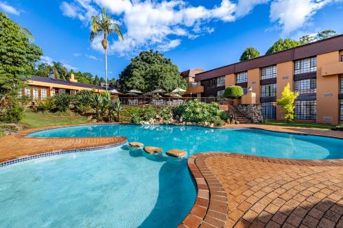 白河African Sky Hotels - Pine Lake Inn的大楼前的游泳池