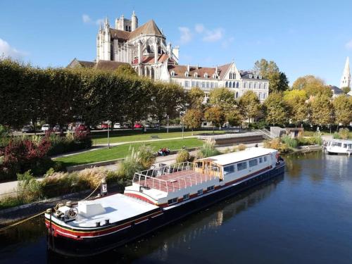 Logement 'la Hulotte'-10 min d'Auxerre-2h de Paris的大型建筑前的水中小船